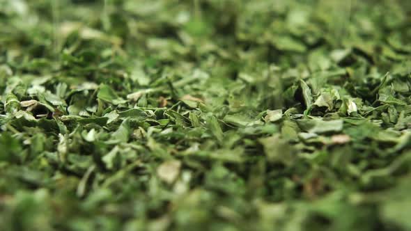 Dried chopped parsley seasoning is sprinkled in slow motion