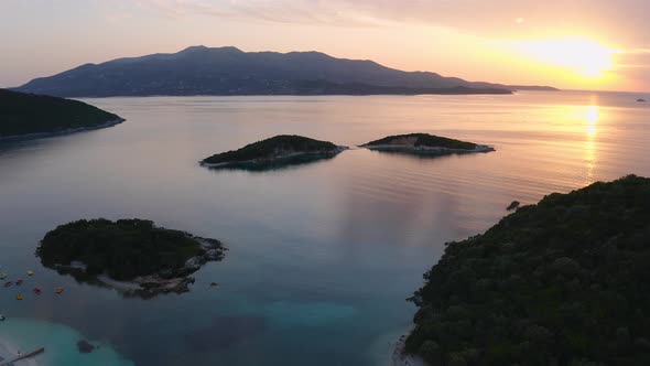 sunbeams shine in background litting the surface of the sea and the islets of Ksamil, in Albania, Eu