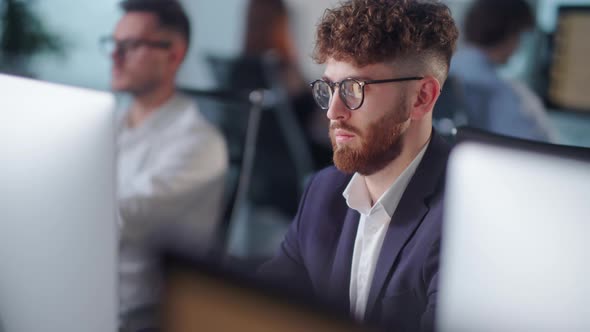 Portrait of Young Entrepreneur in Open Space Office Working on Decktop Computer