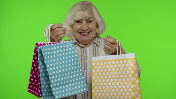 Senior Grandmother Raising Shopping Bags, Celebrating, Satisfied with Purchase, Discount. Chroma Key