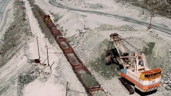 Excavator Loads Iron Ore Into a Freight Train