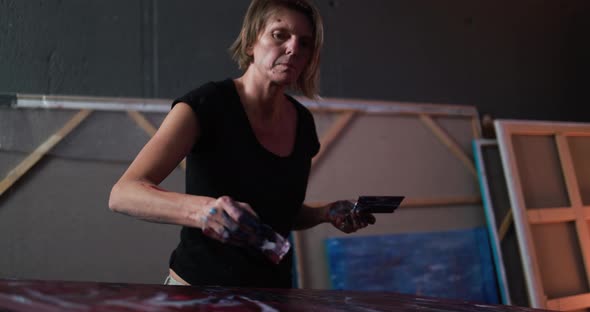 Mature woman painting inside her atelier studio