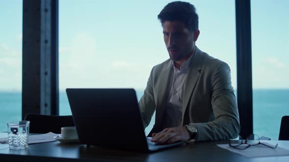 Focused Professional Using Laptop Computer in Office