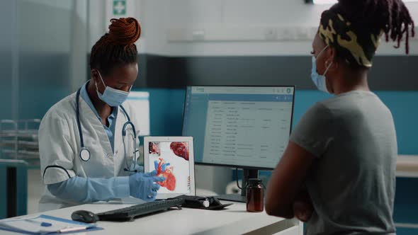 Doctor Pointing at Tablet with Heart Organ on Screen