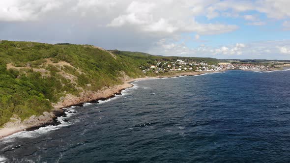 Aerial of rugged coastal landscape of Kullaberg with village Molle in background