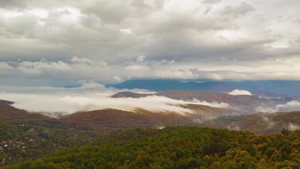 aerial drone Hyperlapse over autumn mountain forest and moving clouds