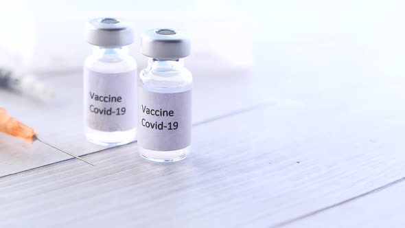 Close Up of Coronavirus Vaccine and Syringe on White Background