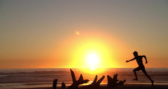 Muchacho Corre en la playa al atardecer