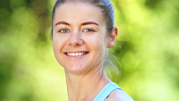 Young woman with fair hair bun turns head