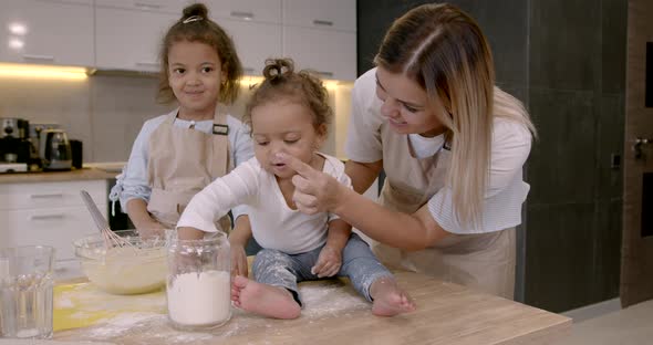 Mother with Kids at the Kitchen Cooking