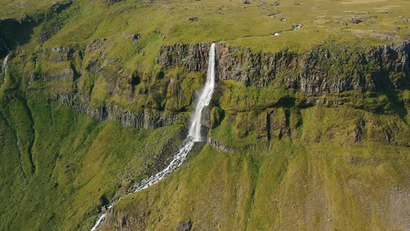 Aerial Drone Footage of Bjarnarfoss Waterfall Green Cliffs and Plateau in Western Iceland