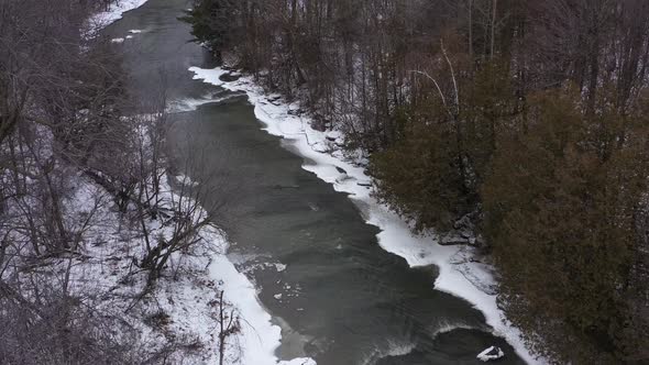 icy winter river between forests aerial high medium wide