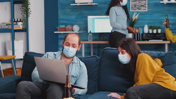 Man with Sitting on Sofa Holding Laptop Talking with Woman