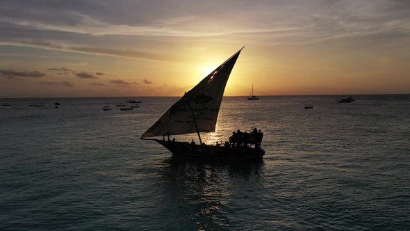 Colorful sunset above the sea surface with sail boats, aerial view Zanzibar.