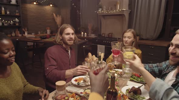 Group of Friends Clanking Glasses at Dinner Party