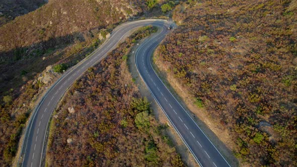 Drone Of Single Car Driving Along Empty Winding Road