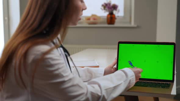 Unrecognizable Blurred Doctor Pointing at Green Screen on Laptop Talking Advertising Web Page Mockup