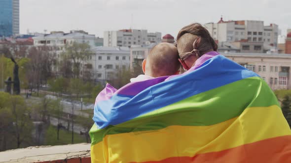 Gay Couple with Rainbow Flag Looking at Cityscape