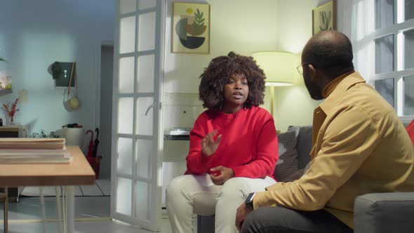 Married African American Couple Sitting on Sofa and Having Fight