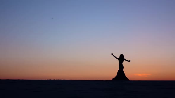 Girl Dancing Belly Dancing on the Beach Against the Sunset, Silhouettes