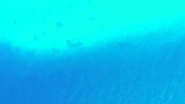 Wide angle aerial clean view of a sandy white paradise beach and blue water background in hi res 4K