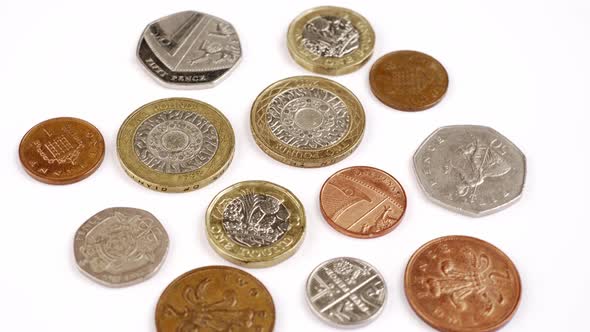 UK Currency pounds coins rotating close up footage against the white background