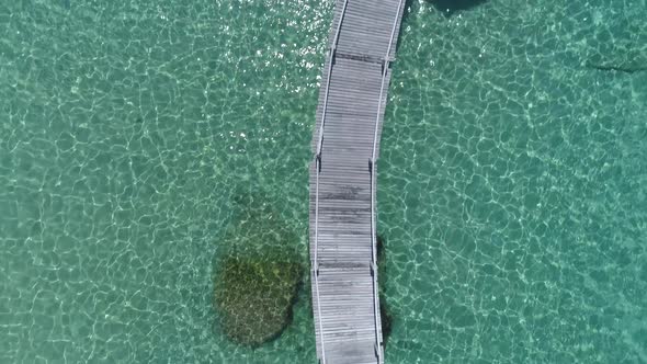 Aerial of a pier in the ocean with a gazebo in the ocean