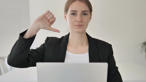 Thumbs Down by Young Businesswoman in Office