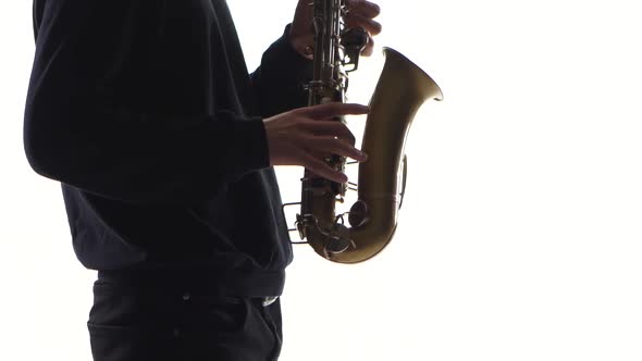 Musician Plays an Old Saxophone. Closeup on White Background