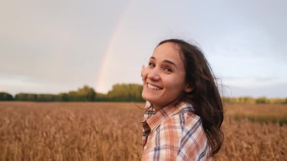 The Girl Holds a Man's Hand and Runs on a Wheat Field. Follow Me To the Rainbow.