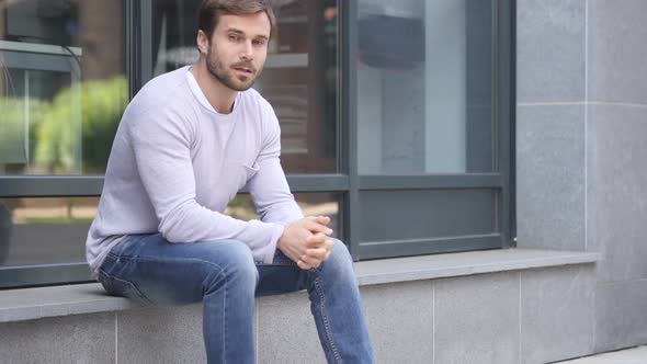 Thumbs Down By Handsome Man Sitting Outside Office Window