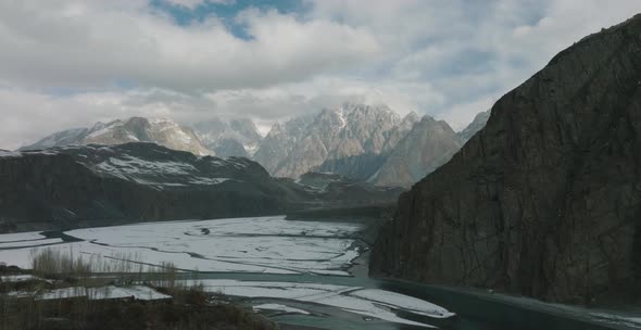 Drone shot of Hussaini Suspension Bridge over the Hunza River in cloudy Himalaya mountains. Hussaini