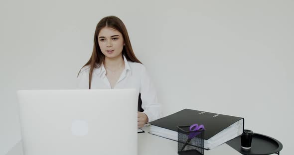 Happy Young Girl Having Pleasant Online Video Chat on Laptop at Workplace