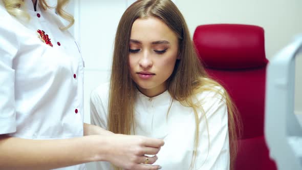 Doctor with patient in medical office. Young woman having eyes examined by eye doctor