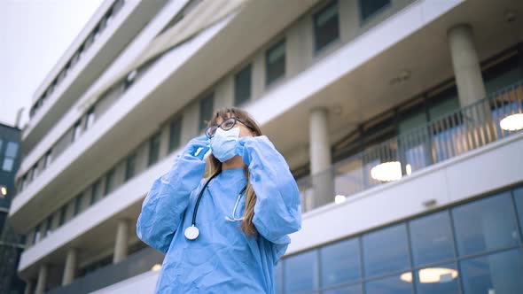 Cheerful Young Female Doctor in Glasses Takes Off Medical Mask