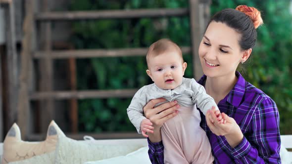 Medium Closeup Young Hipster Mother Posing with Cute Baby Son Enjoying Weekend at Home