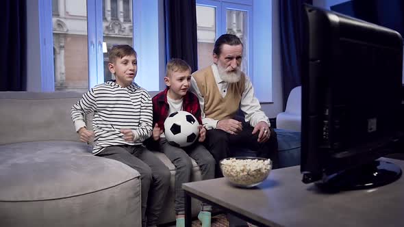 Boys and Their Senior Bearded Granddad which Sitting on the Couch at Home