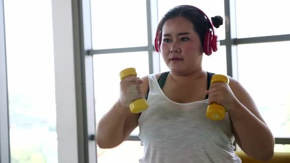 Overweight young woman in sportswear exercising to lose weight at home