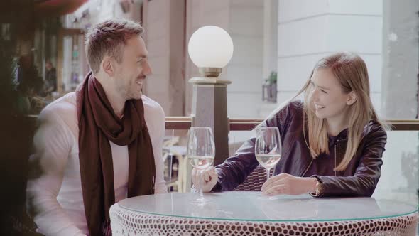 Couple Drinking Wine And Having Fun Together At Restaurant Outdoors