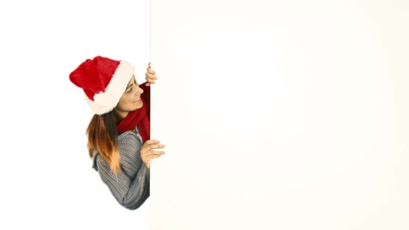 Beauty brunette in santa hat pointing white poster