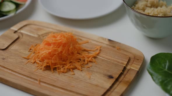 Close-up of  Female hands grate carrots on white table. Top view Cooking Salad.