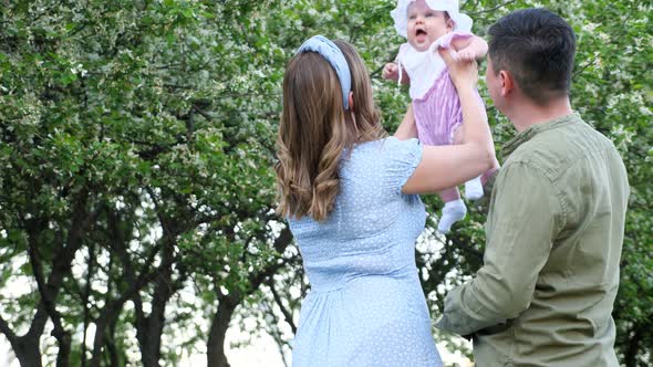 Delighted Mother Tosses Baby Daughter and Plays with Kid