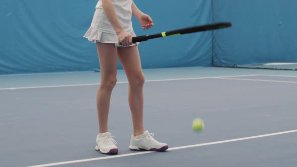 Girl Bouncing Tennis Ball On Floor