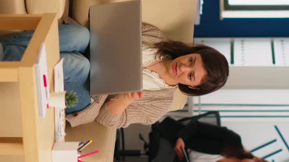 Business Woman Talking During Video Conference Calling From Laptop Sitting on Couch