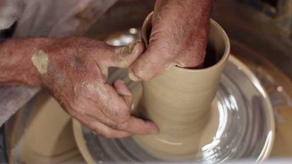 Potter's Hands Make Clay Glass Using Potter's Wheel