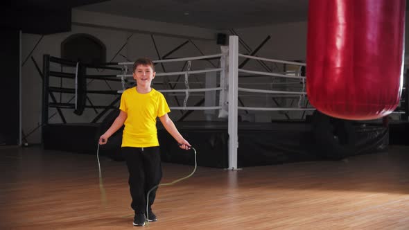 A Little Smiling Boy Trying Jumping Over the Rope Near the Boxing Ring