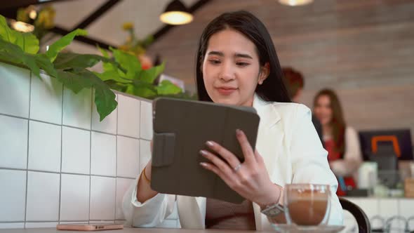 Thoughtful business woman thinking over future business plan at coffee shop, taking notes in tablet