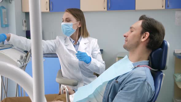 Female Dentist Starting Check-up on Male Client