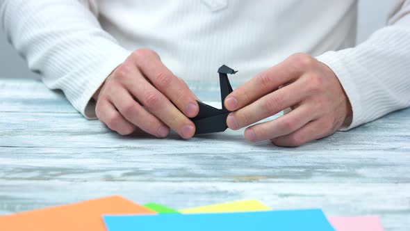 Black Origami Swan on Wooden Background.