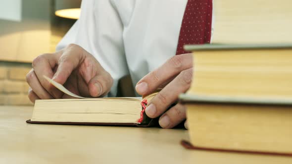 Closeup of Hands Leafing Through a Book in the Library